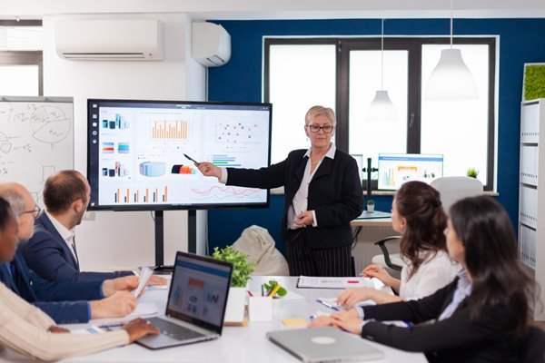 senior-woman-company-leader-brainstorming-conference-room-corporate-staff-discussing-new-business-application-with-colleagues-looking-screen-1.jpg