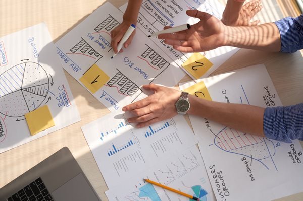 top-view-creative-team-discussing-business-graphs-drawn-marker-pens-1.jpg